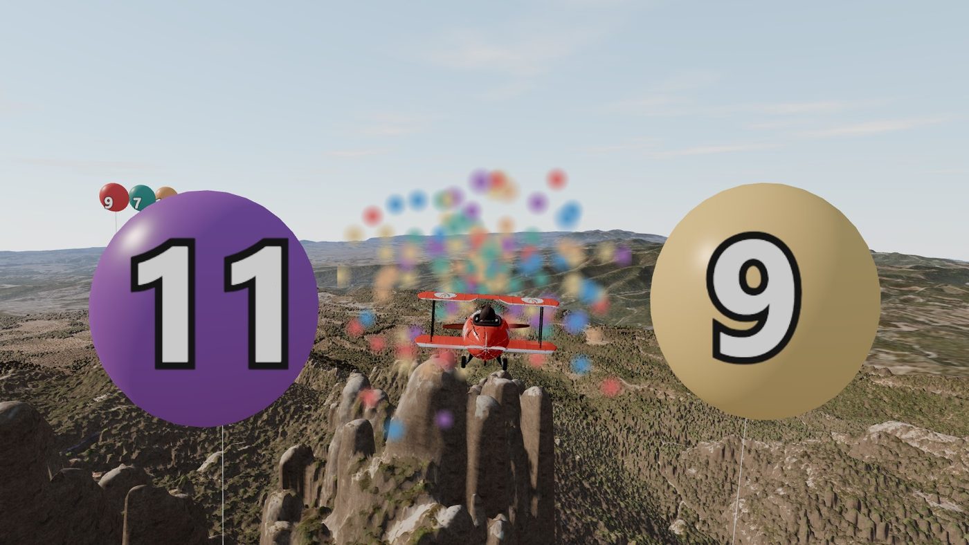 L'avioneta acaba de rebentar el globus del 8 i en surt confeti; als costats queden els globus 11 i 9, sobre les agulles de Montserrat